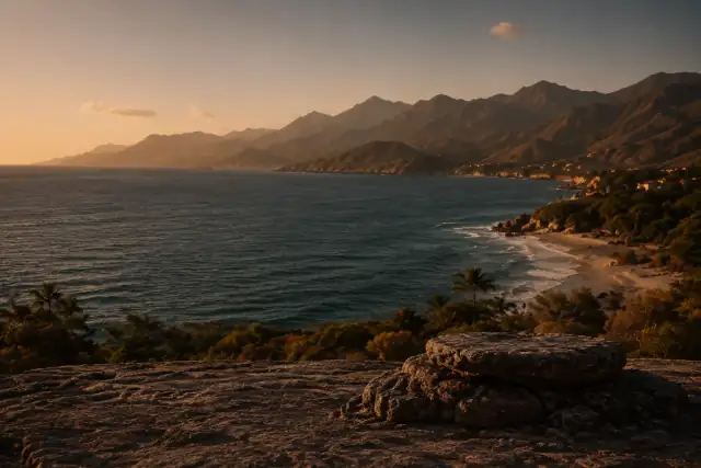 Costa al atardecer, con montañas, mar y roca en primer plano
